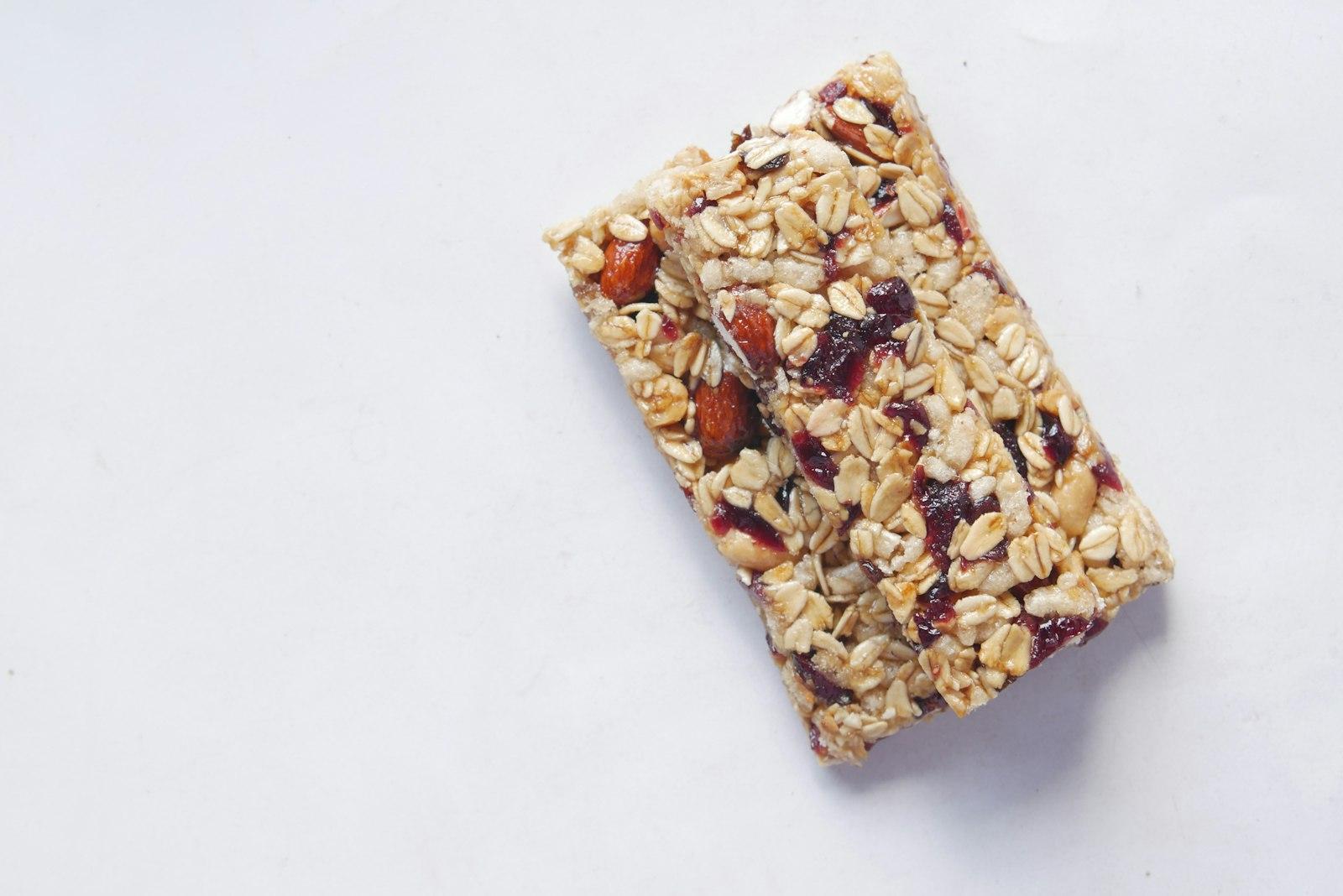 An oat and fruit snack bar on a pale surface