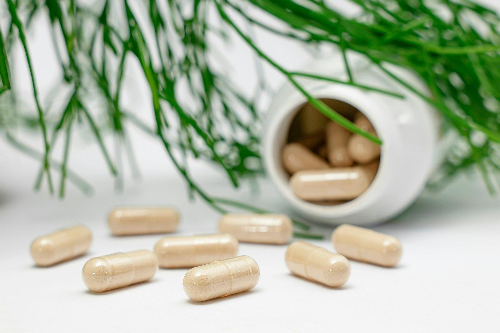 Supplement capsules spilling from a white bottle